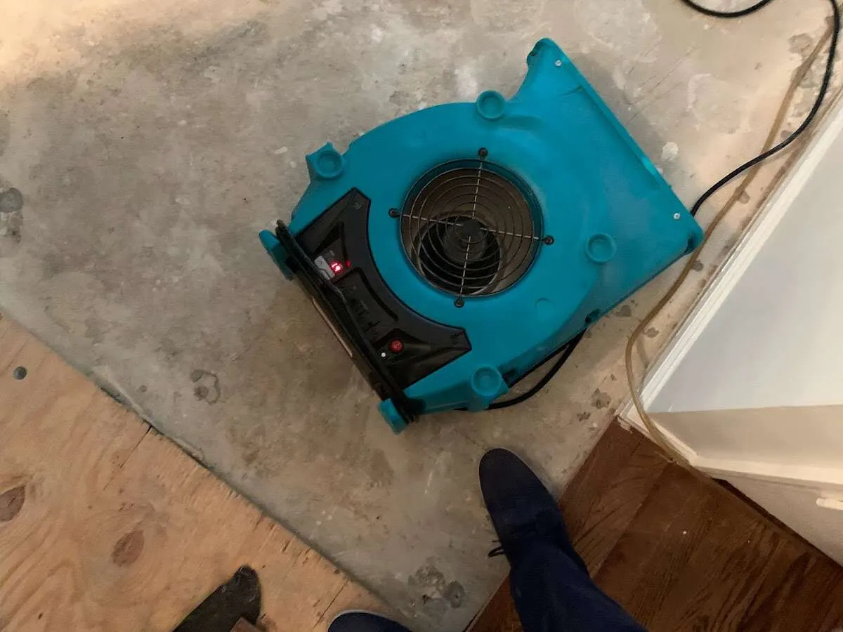 Air mover drying subfloor during Commercial Water Damage Restoration in Godley